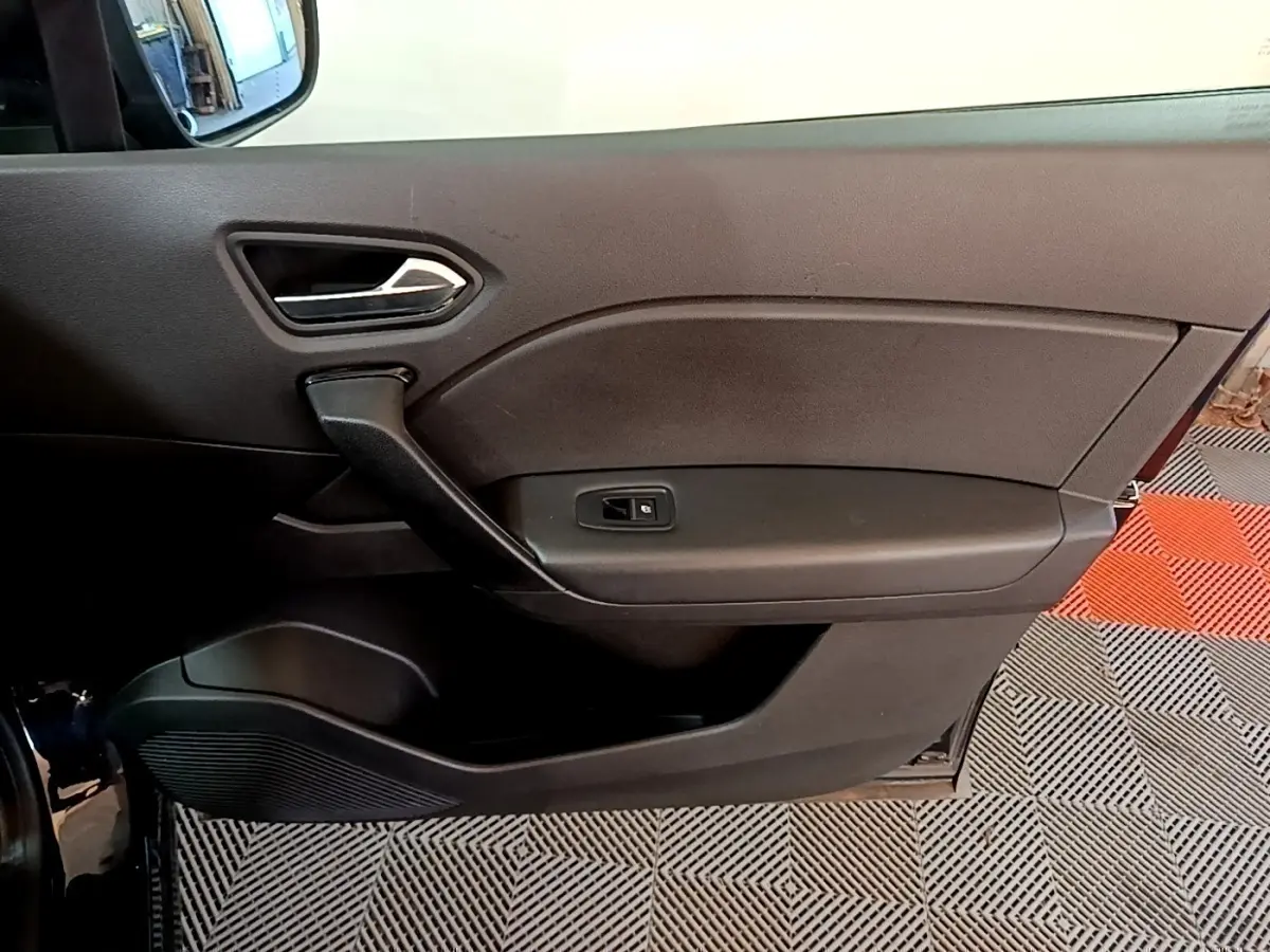 Vue intérieure côté gauche de la porte noire du Renault Captur 2021 avec poignée et commande de fenêtre électrique.