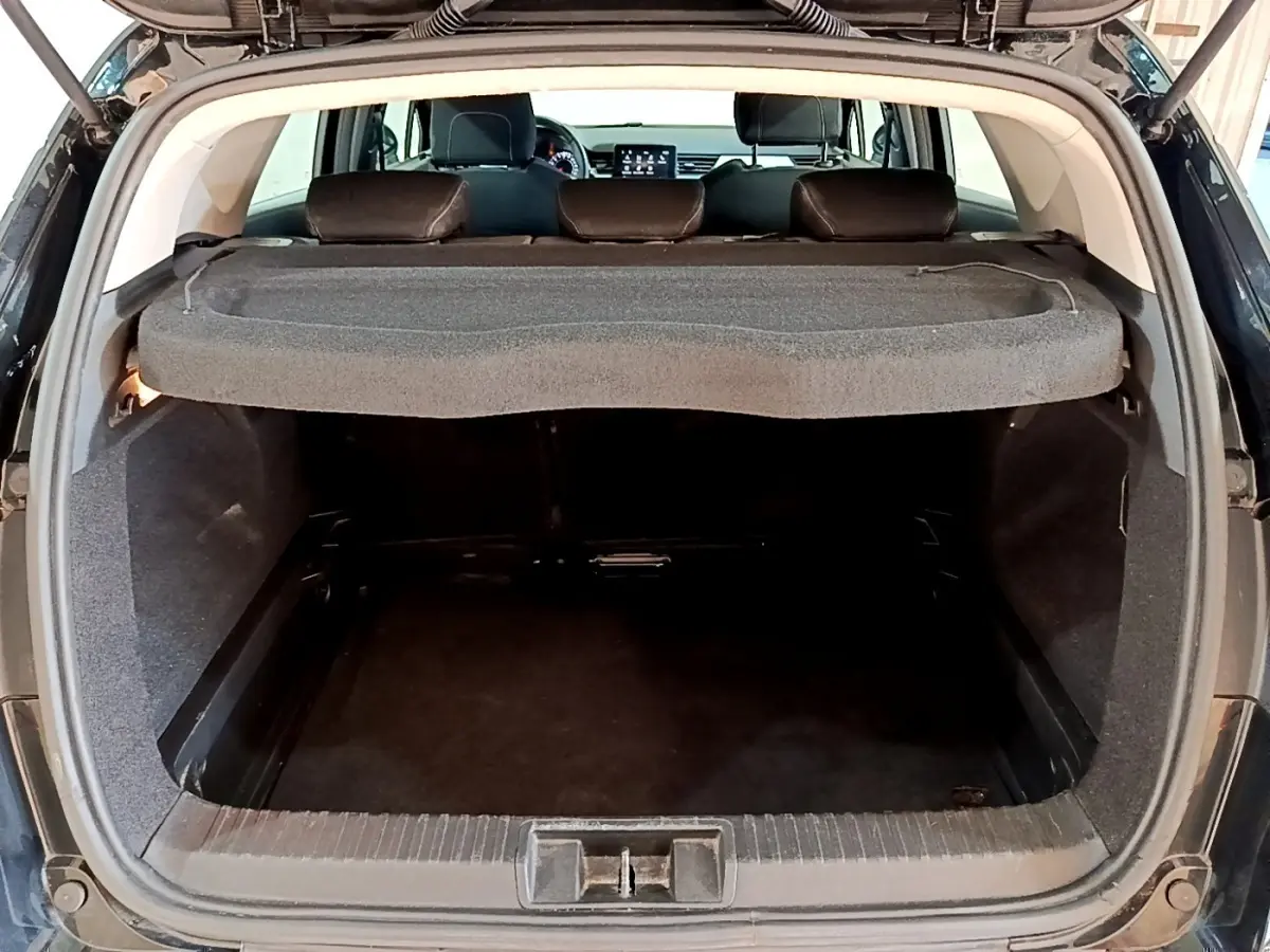 Coffre ouvert vu de l'arrière d'un Renault Captur noir 2021, avec tablette cache-bagages et banquette arrière visible.