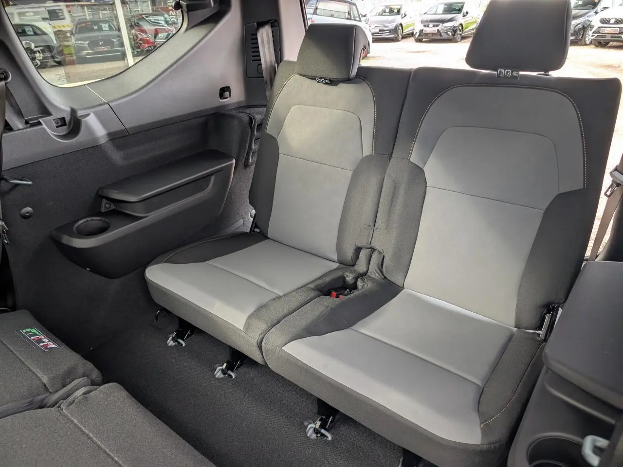 Vue intérieure sur la banquette arrière grise et noire du Dacia Jogger 2025, côté droit avec tablette et porte-gobelet.