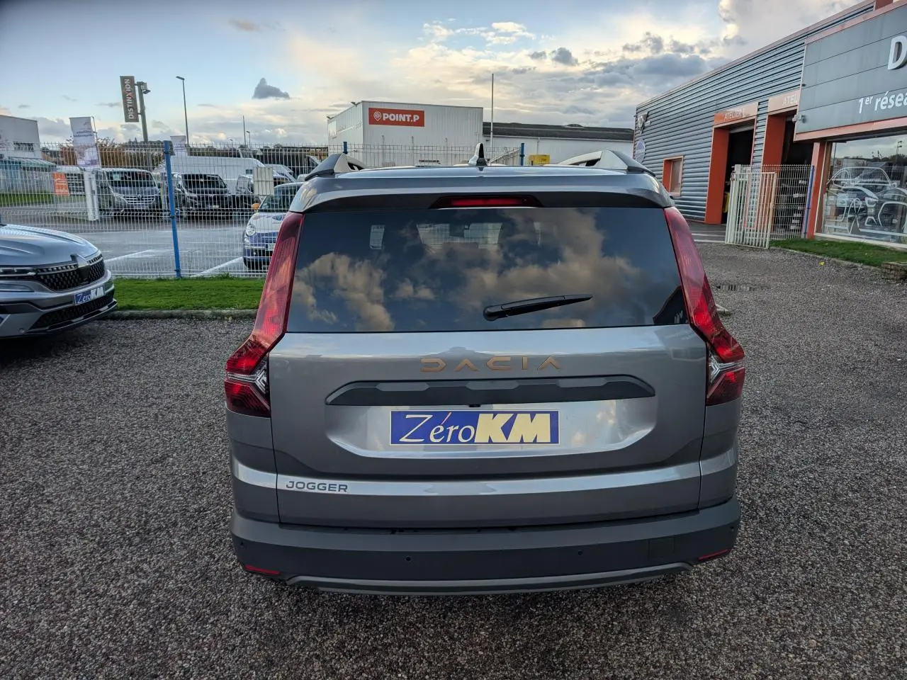 Vue arrière d’un Dacia Jogger gris métallisé avec logo brun cuivré et feux verticaux distinctifs.