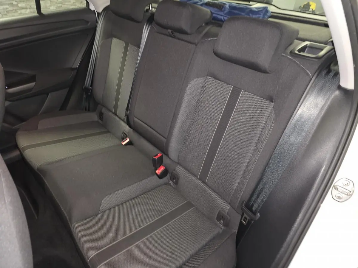 Banquette arrière en tissu gris foncé du Volkswagen T-Roc blanc, vue côté droit avec ceintures de sécurité visibles.