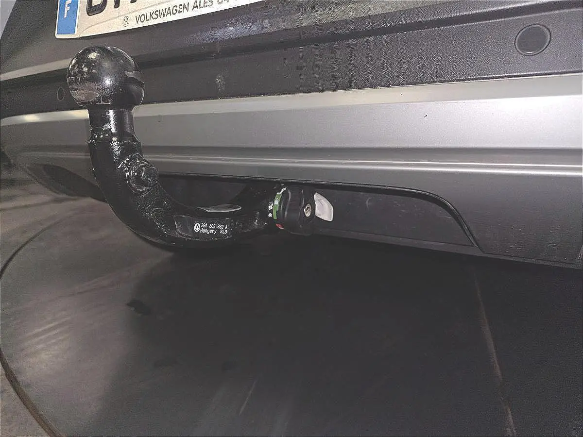 Gros plan sur l'attelage amovible noir fixé au pare-chocs arrière blanc du Volkswagen T-Roc 2022.