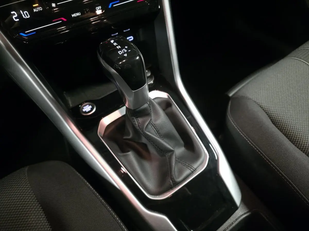 Le levier de vitesse automatique noir et argenté du Volkswagen T-Roc 2022, avec sellerie tissu gris.