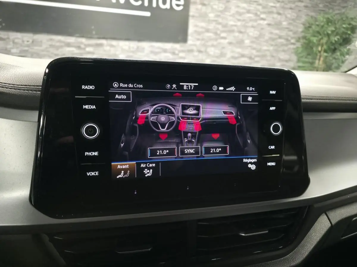 Écran tactile central du Volkswagen T-Roc 2022 affichant les réglages de climatisation avec interface noire brillante.
