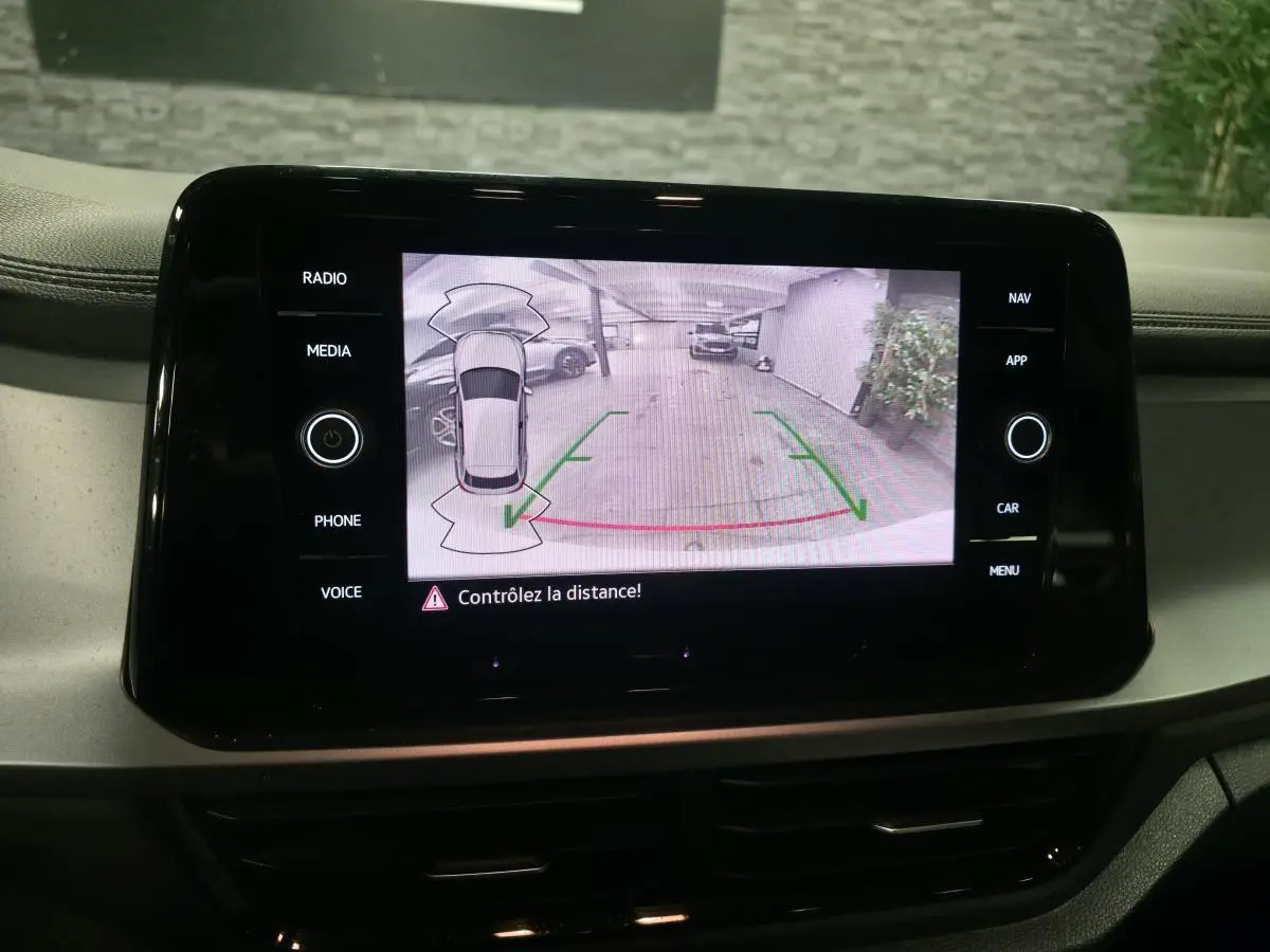 Écran tactile intérieur du Volkswagen T-Roc blanc montrant la caméra de recul avec guidage de trajectoire.