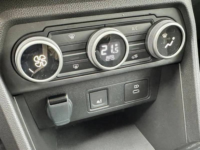 Gros plan sur la console de climatisation noire avec commandes rotatives et affichage digital du DACIA JOGGER 1.6 hybrid 2025.