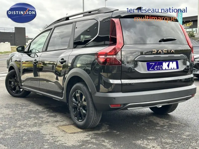 Vue 3/4 arrière droite du Dacia Jogger noir nacré métallisé avec barres de toit et jantes noires brillantes.