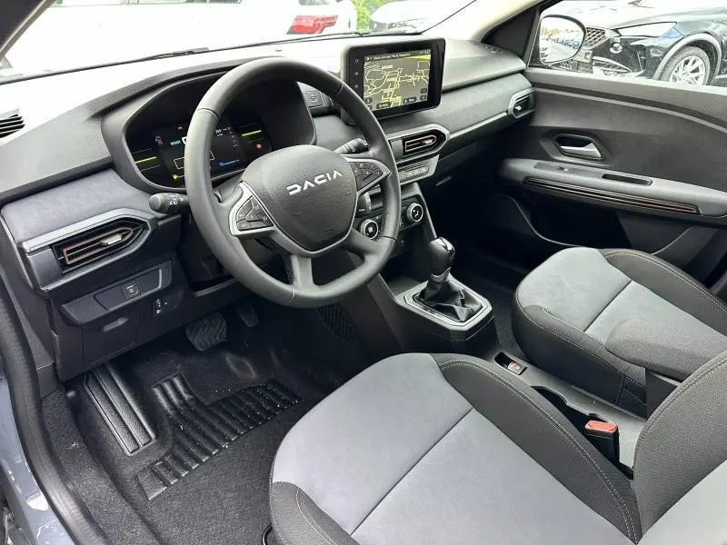 Vue intérieure côté conducteur du Dacia Jogger 2025, tableau de bord noir avec écran tactile et volant multifonction.