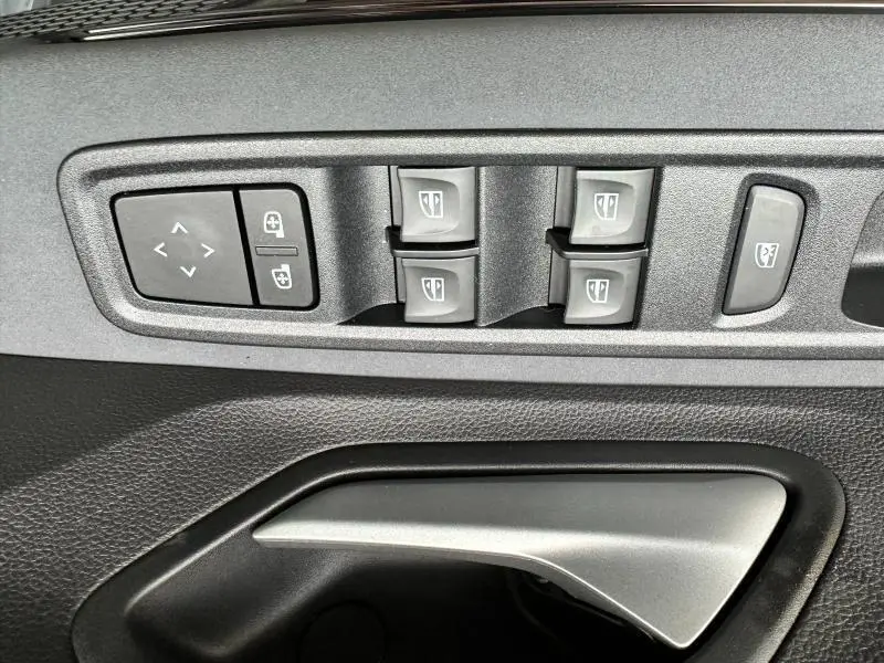 Gros plan sur les commandes de lève-vitres et réglages des rétroviseurs intérieurs du Dacia Jogger noir nacré.