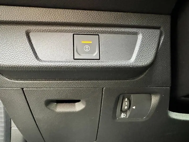 Détail intérieur montrant le bouton de verrouillage central et la molette de réglage des phares du Dacia Jogger noir nacré.
