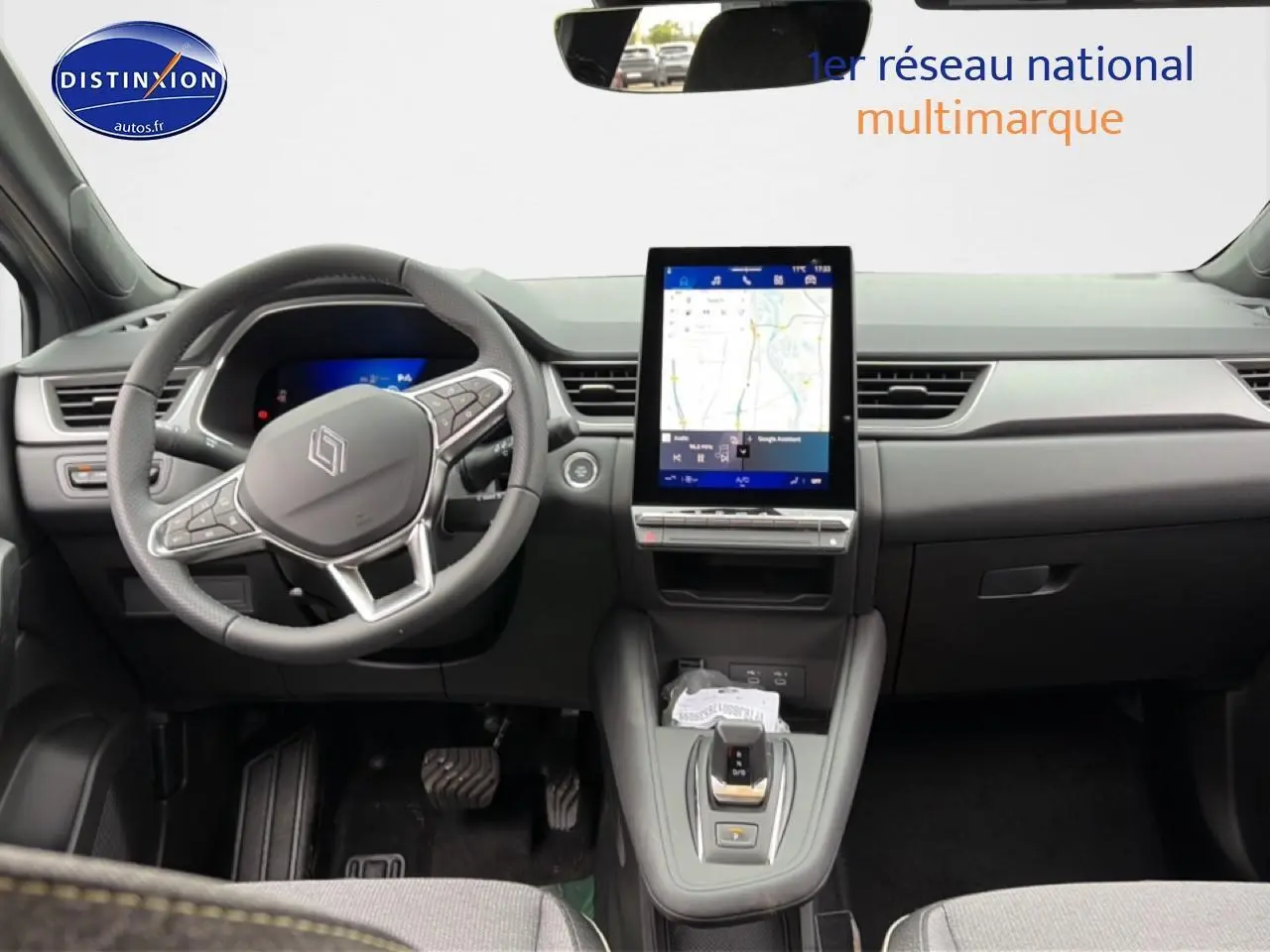 Vue intérieure frontale du tableau de bord du Renault Symbioz gris schiste avec écran tactile vertical et volant multifonction.