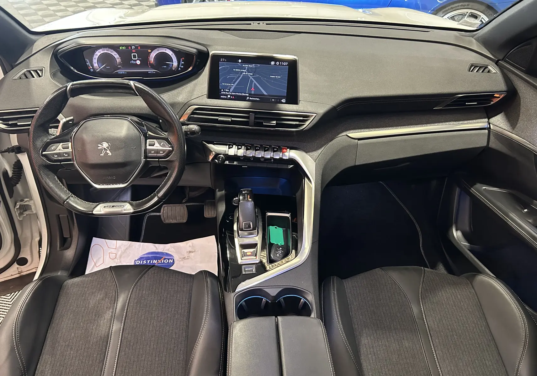 Vue intérieure frontale du tableau de bord et volant du Peugeot 3008 blanc, avec écran tactile et console centrale moderne.