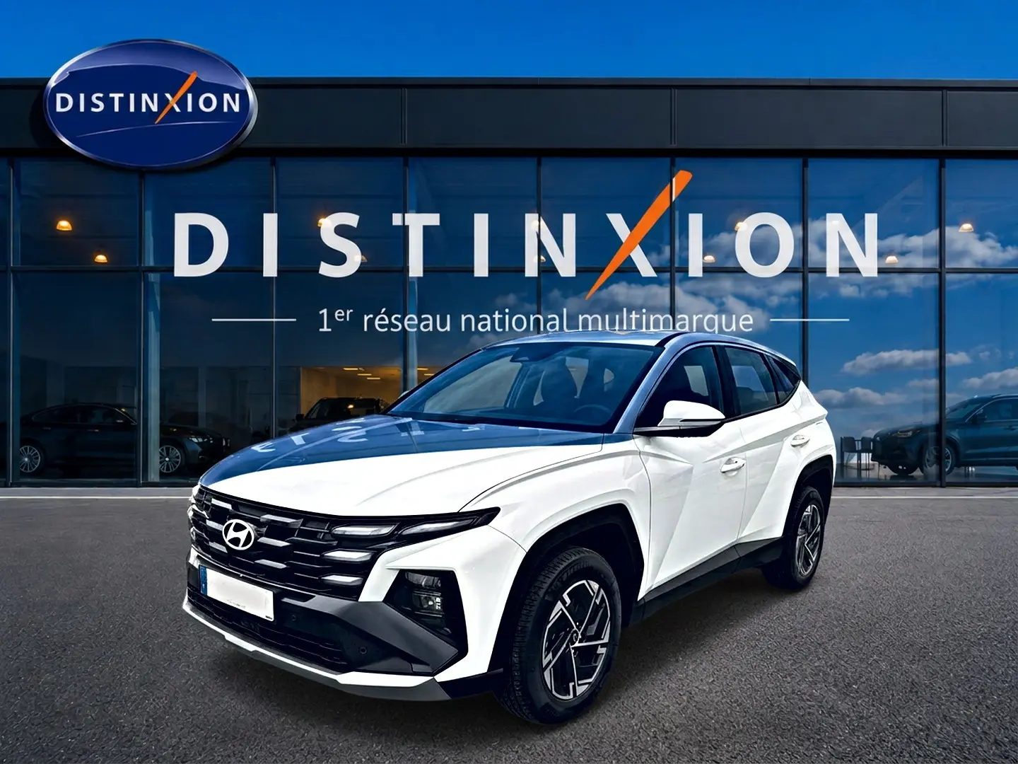 Hyundai Tucson blanc en 3/4 avant droit, avec calandre noire distinctive et jantes alliage 17 pouces.