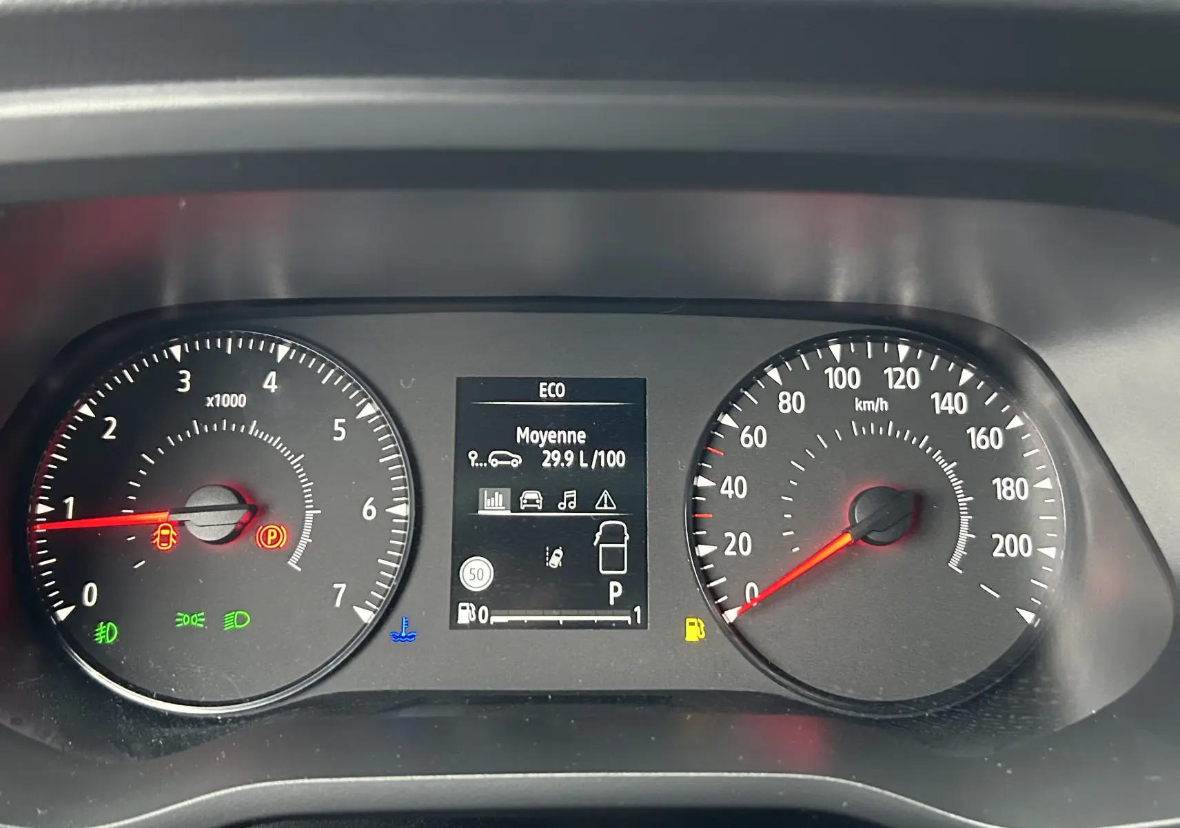 Tableau de bord du Renault Trafic Fourgon gris, affichant compte-tours, vitesse et écran central avec consommation moyenne.