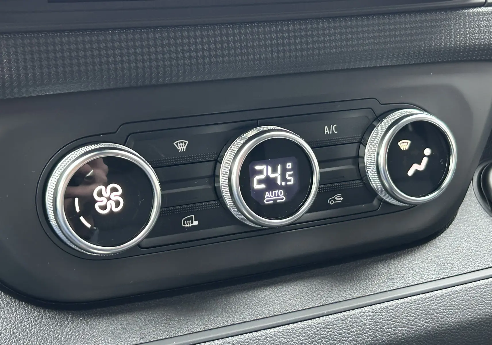 Gros plan sur les commandes de climatisation digitale du Renault Trafic Fourgon 2025, affichant 24,5°C en mode automatique.