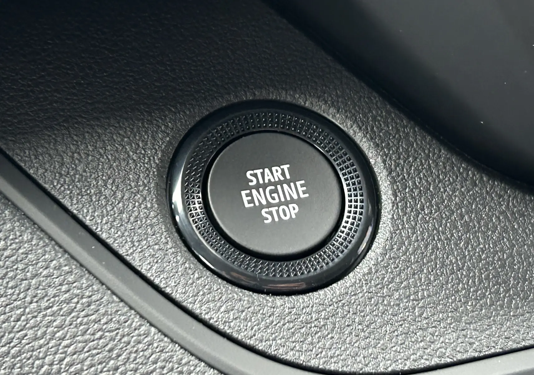 Gros plan sur le bouton Start Engine Stop noir dans l’habitacle du Renault Trafic Fourgon gris Comète.
