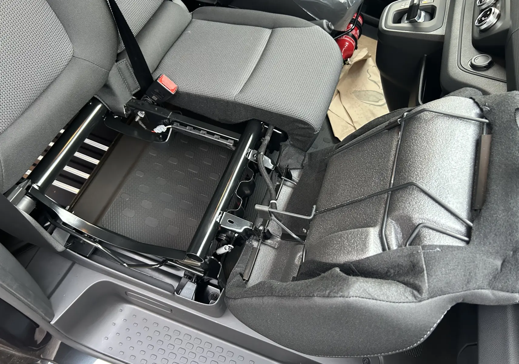 Vue intérieure rapprochée du siège avant droit gris du Renault Trafic Fourgon 2025 avec assise relevée montrant la structure métallique.