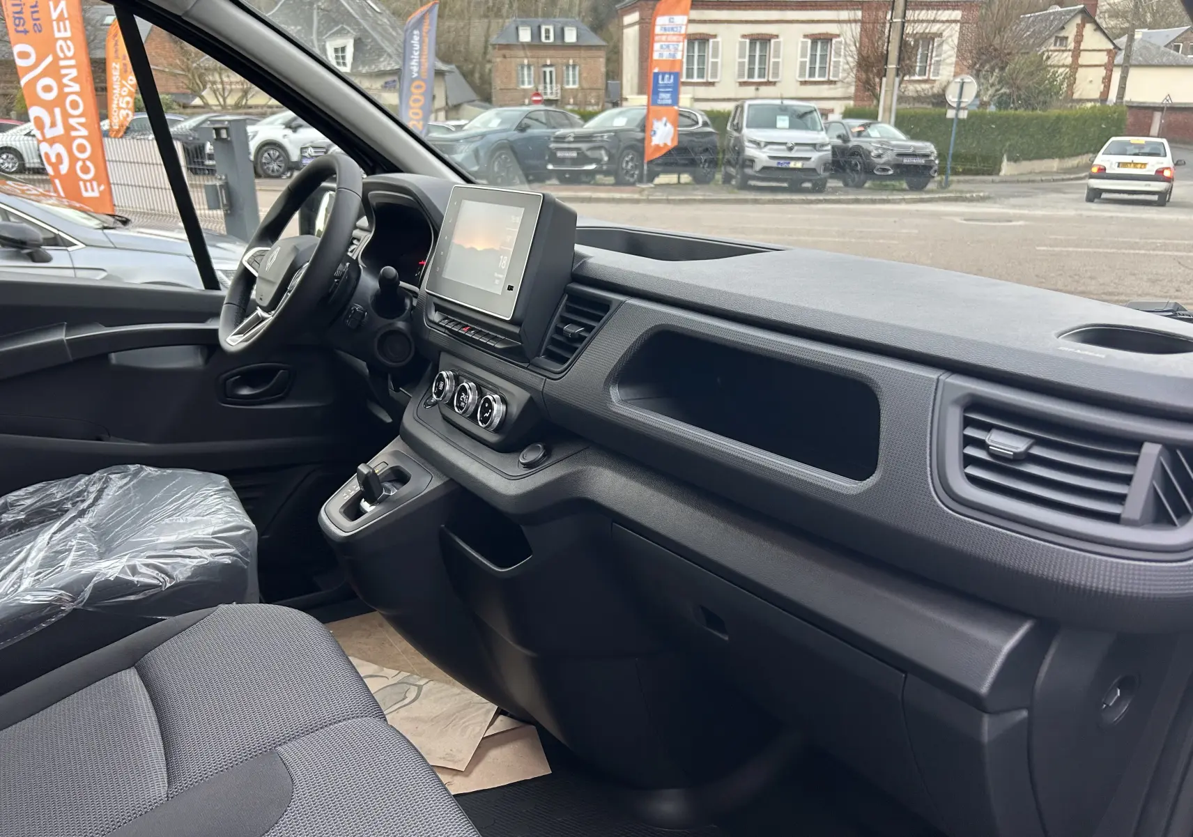 Vue intérieure côté conducteur du Renault Trafic Fourgon 2025, montrant le tableau de bord moderne et l’écran tactile central.