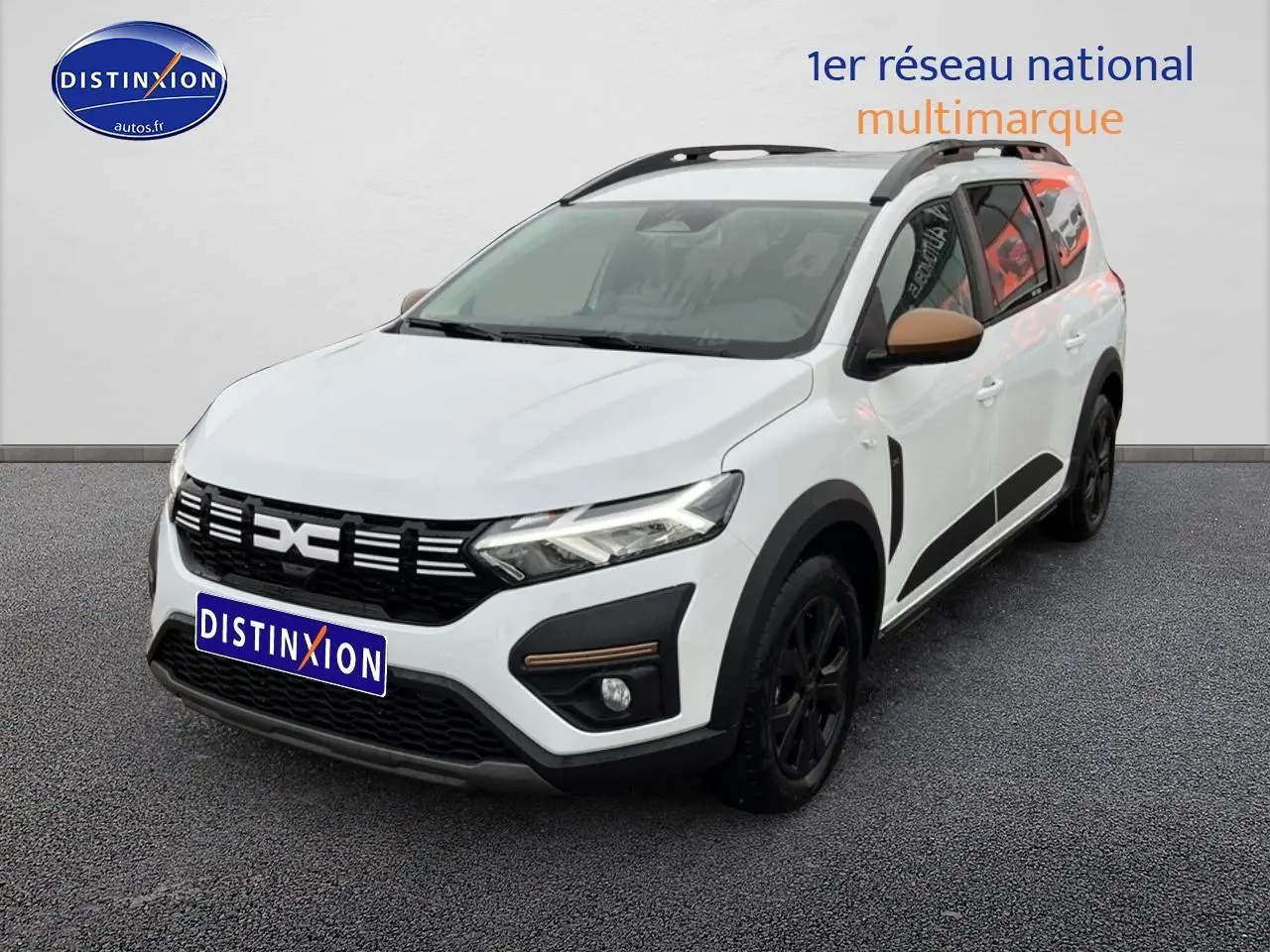 Vue 3/4 avant droite d'un Dacia Jogger blanc avec rétroviseurs marron et jantes noires sur fond neutre.