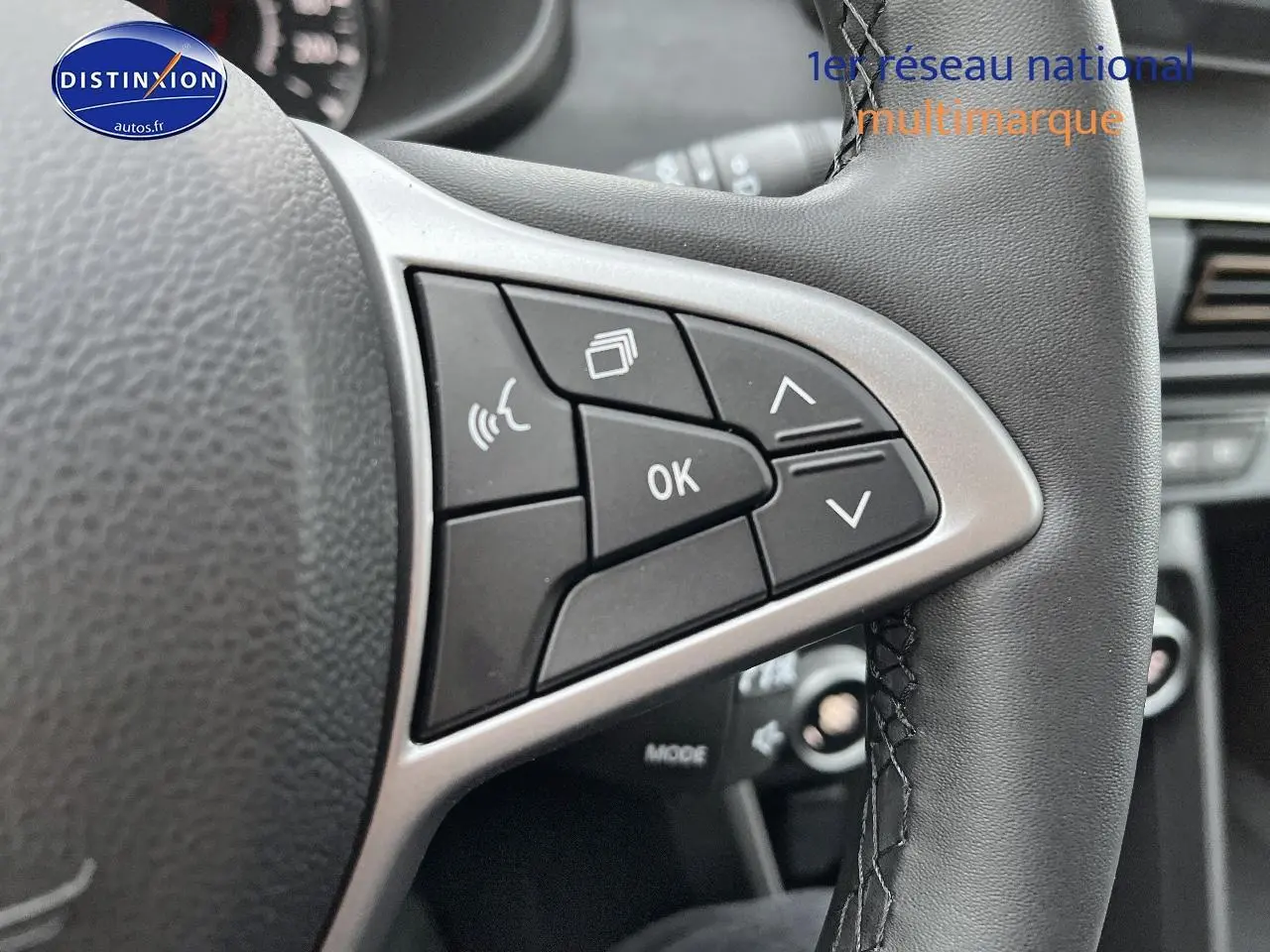 Gros plan sur les commandes multifonctions du volant cuir noir du Dacia Jogger blanc, version 2025.