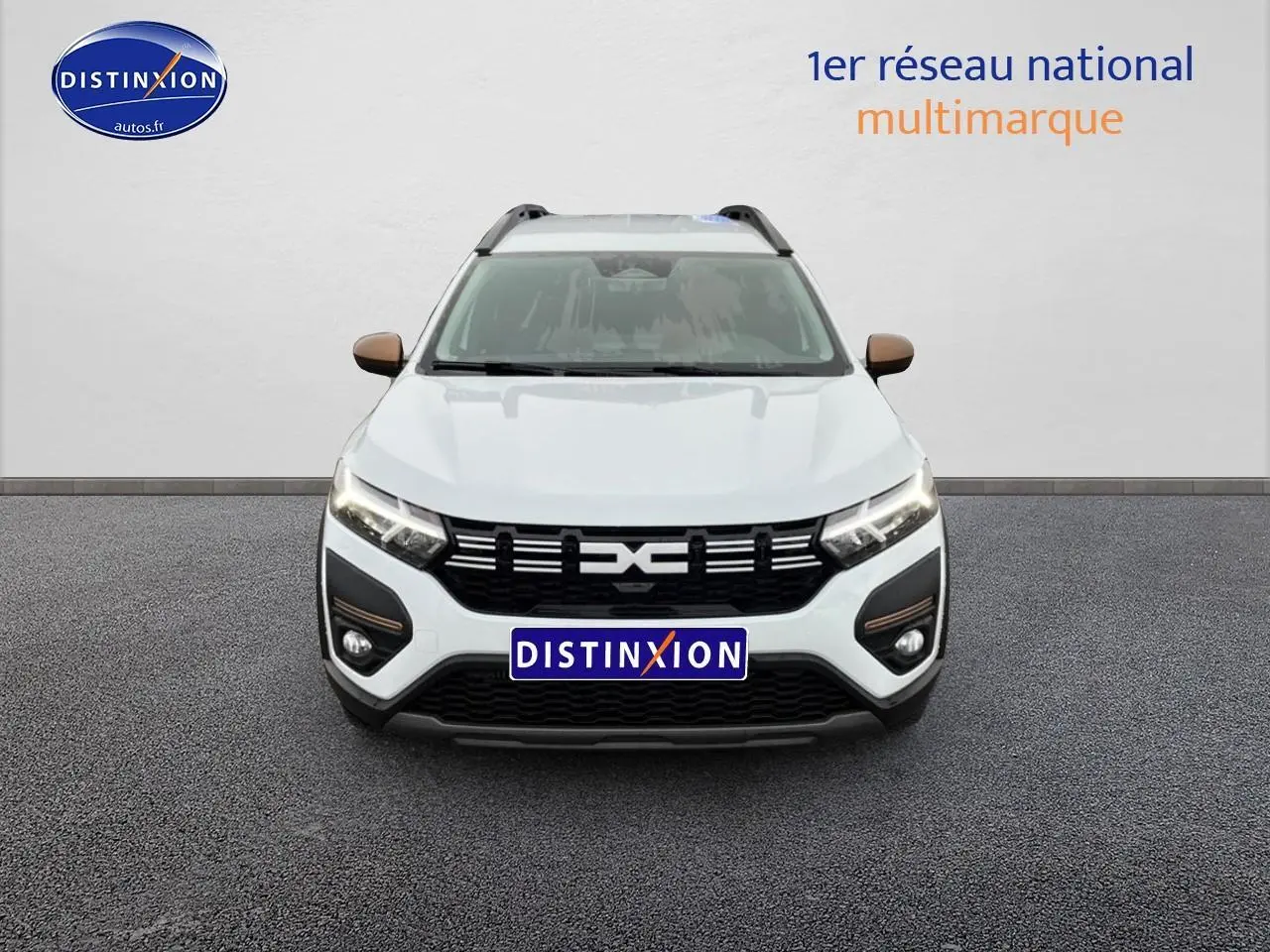 Vue de face du Dacia Jogger blanc 2025 avec calandre noire et rétroviseurs couleur bronze.