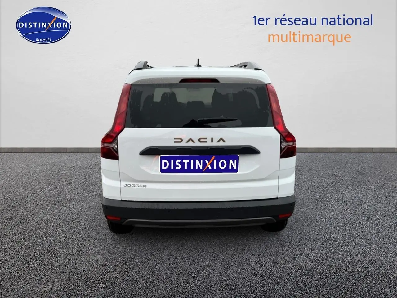Vue arrière d'un Dacia Jogger blanc 2025 avec feux arrière verticaux et barres de toit visibles.