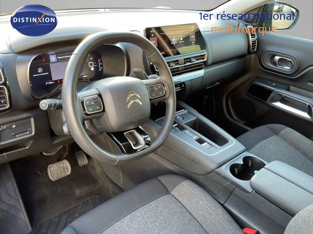 Intérieur du Citroën C5 Aircross 2025, vue côté conducteur, tableau de bord moderne avec écran tactile et volant cuir noir.