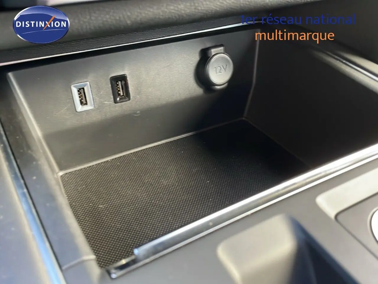 Gros plan sur la console centrale du Citroën C5 Aircross 2025, montrant prises USB et prise 12V dans un intérieur noir.