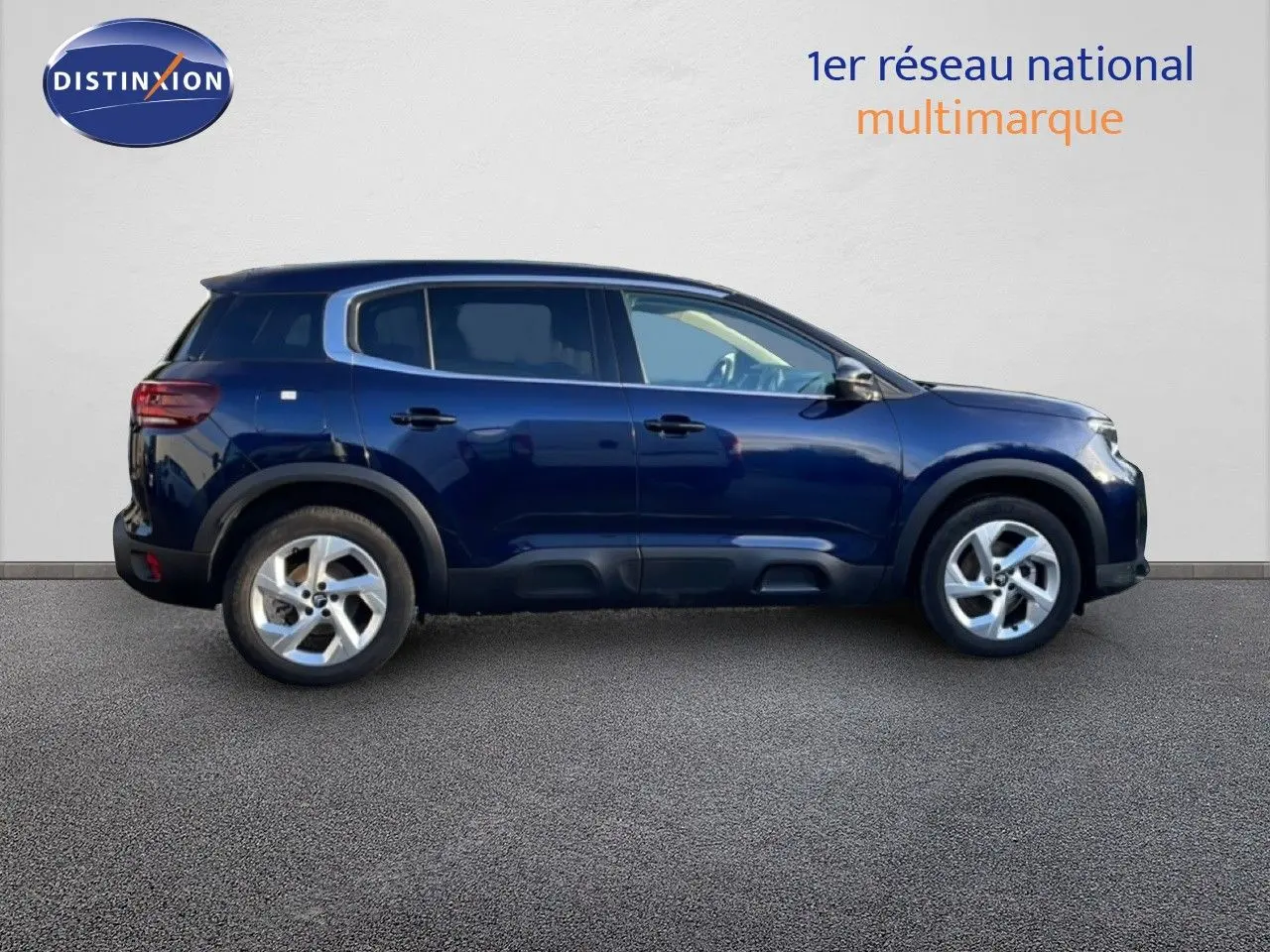 Vue de profil côté gauche d'un Citroën C5 Aircross bleu Eclipse métal, avec protections noires sur les bas de caisse.