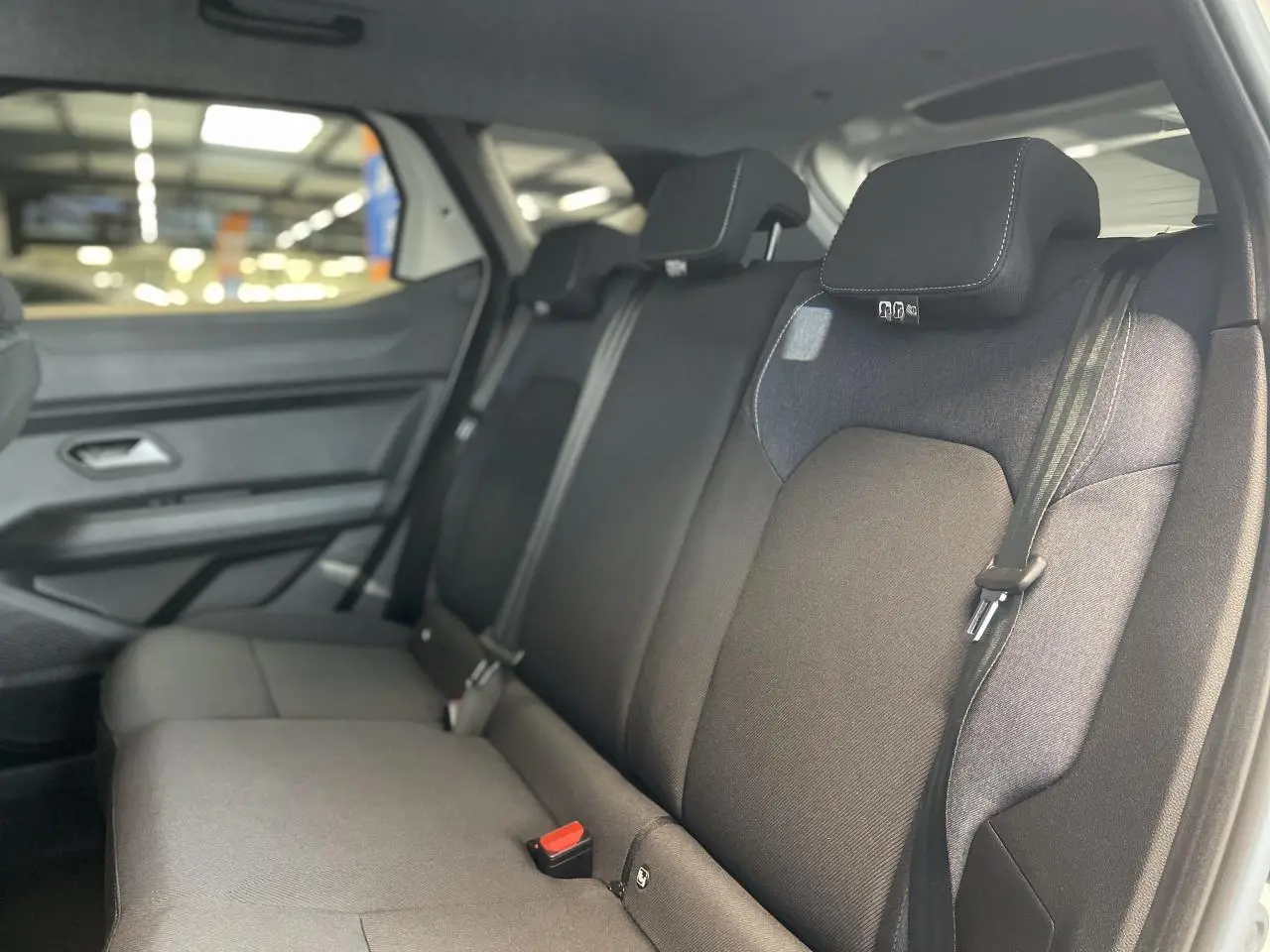 Vue intérieure côté droit sur la banquette arrière en tissu gris foncé du Dacia Duster 2025.