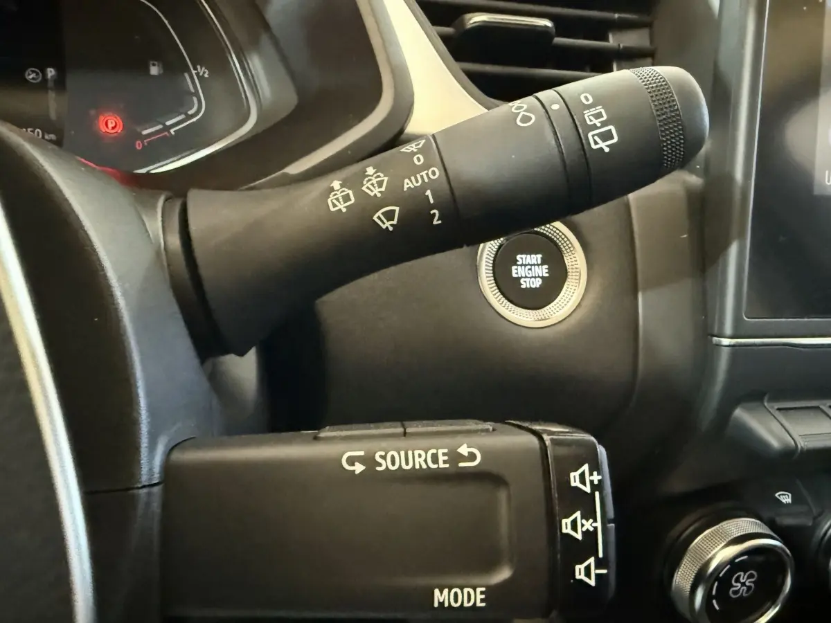 Gros plan sur commandes au volant et bouton démarrage du tableau de bord noir du Renault Captur bleu hybride 2024.