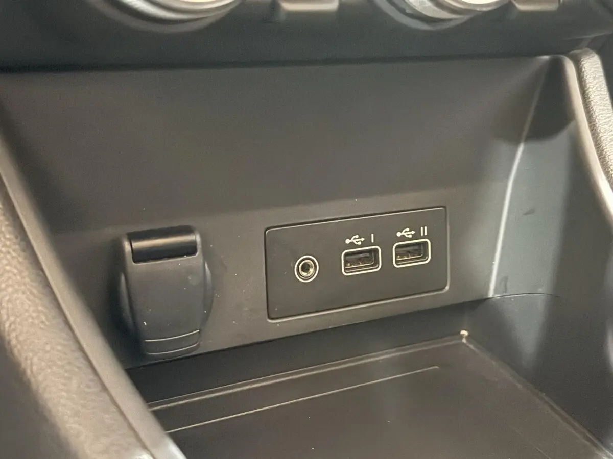 Gros plan sur les ports USB et prise 12V dans l’habitacle du Renault Captur bleu 2024 full hybrid.
