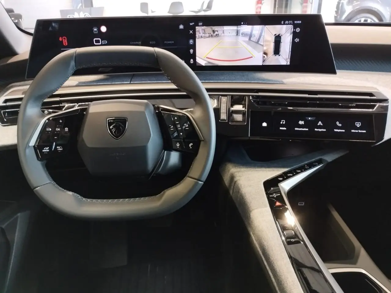 Vue intérieure du tableau de bord du Peugeot 3008 Hybrid 2025 avec volant compact et double écran incurvé flottant.