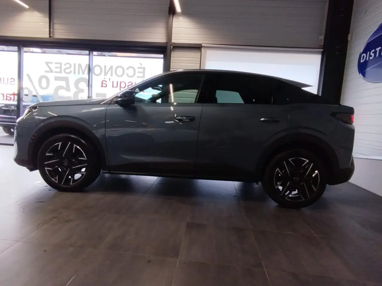 Vue latérale droite d'un Peugeot 3008 2025 hybride en bleu métallisé avec jantes alliage noires brillantes.