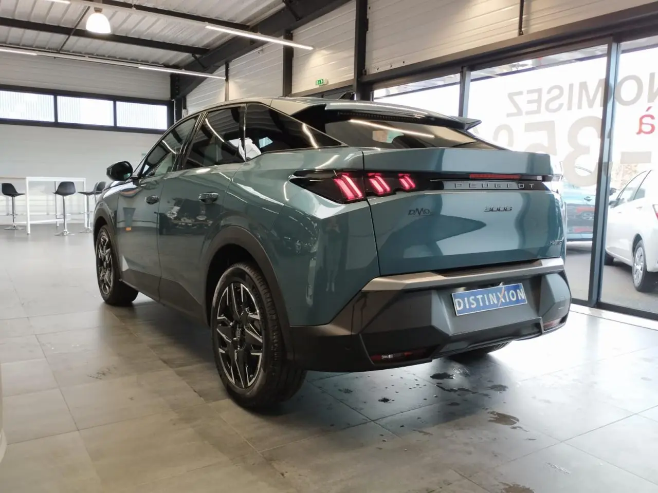 Vue 3/4 arrière droite du Peugeot 3008 hybride bleu métallisé avec feux arrière LED à 3 griffes et jantes alliage noires.