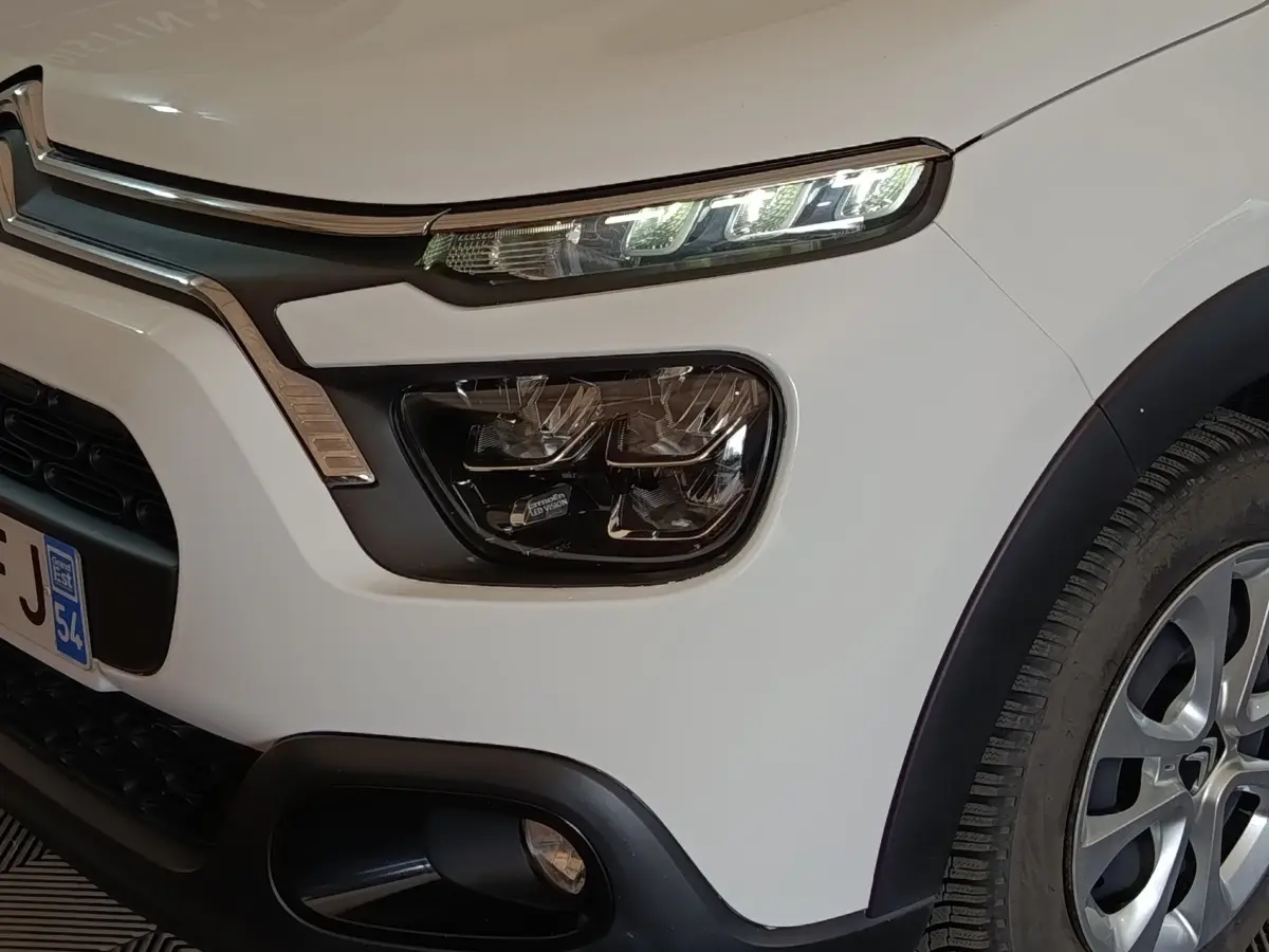 Vue 3/4 avant droit d'une Citroën C3 blanche avec phares LED et antibrouillards intégrés.