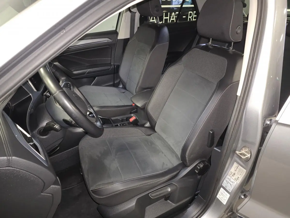 Vue intérieure côté conducteur du Volkswagen T-Roc gris 2022, mettant en valeur les sièges en sellerie Artvelours noir.