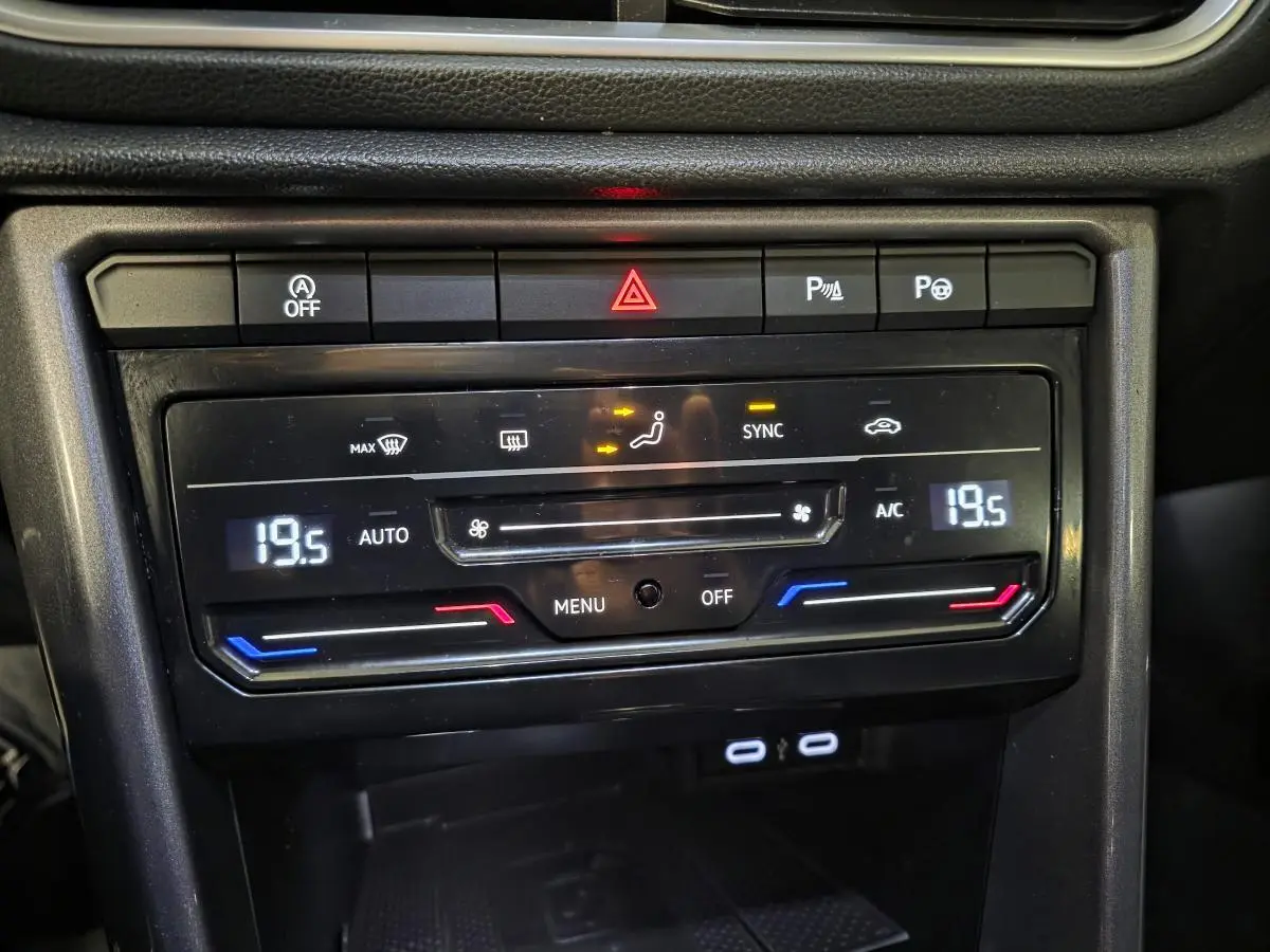 Détail du tableau de bord noir du Volkswagen T-Roc 2022 montrant la climatisation automatique bi-zone à 19,5°C.