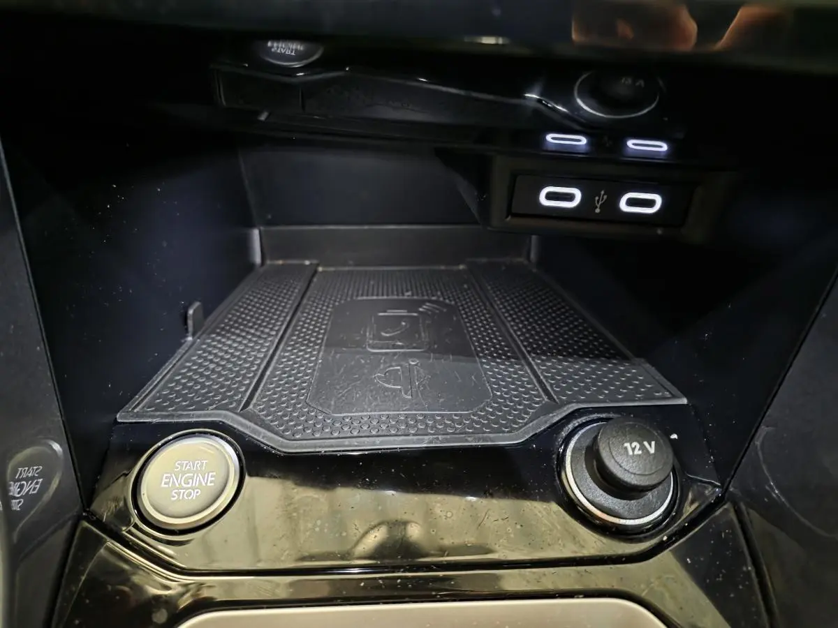 Gros plan sur la console centrale noire du Volkswagen T-Roc 2022, avec bouton start/stop et prise 12V visibles.