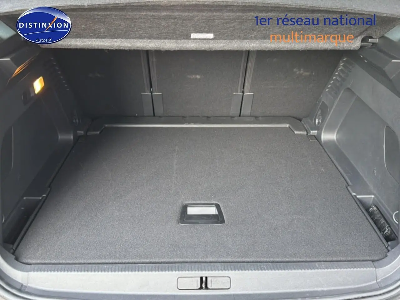 Coffre ouvert vu de l'arrière d'un Citroën C5 Aircross gris platinium, espace de chargement plat et propre.
