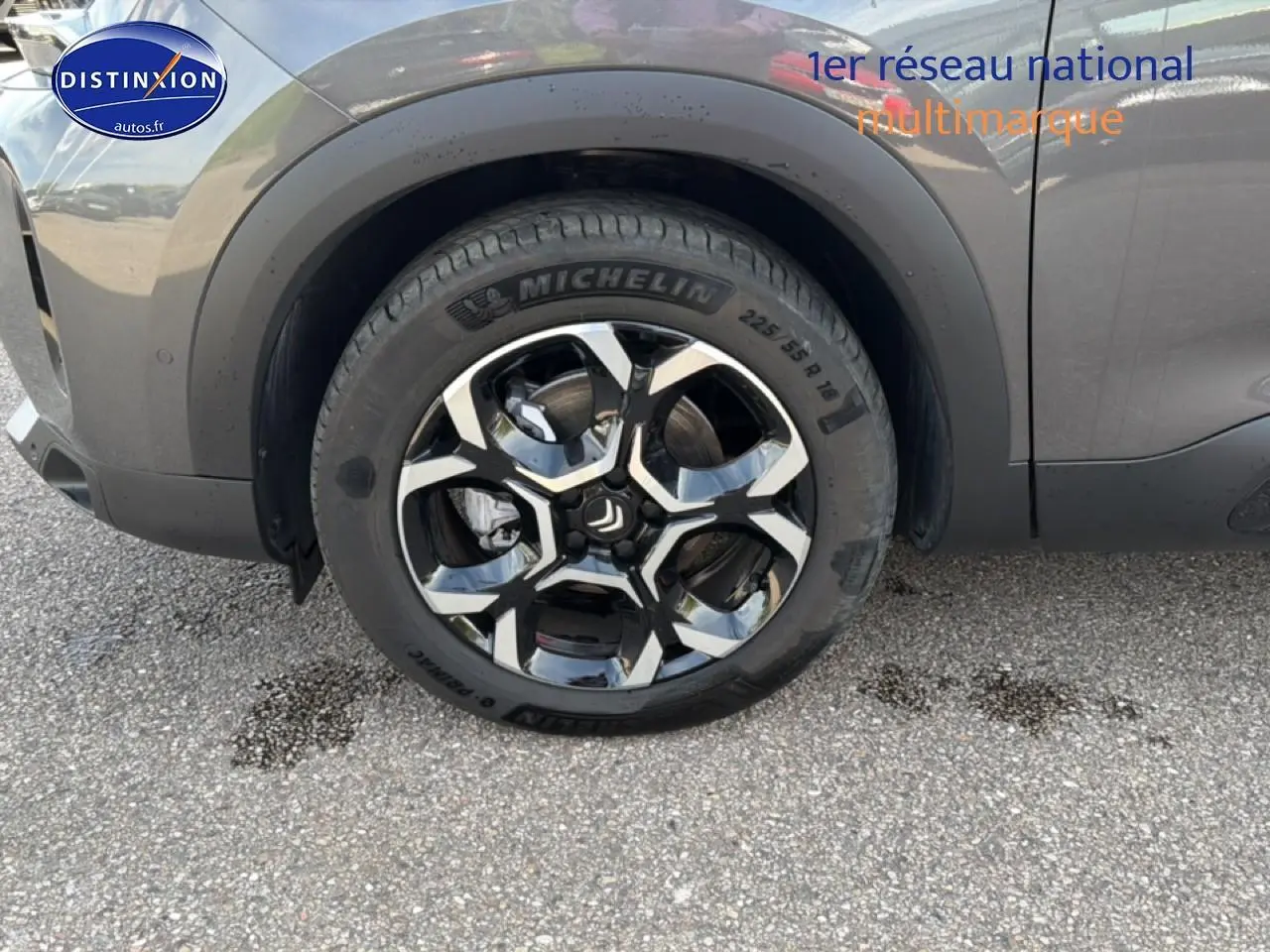 Gros plan sur la roue avant droite avec jante alu noire et grise du Citroën C5 Aircross gris platinium.