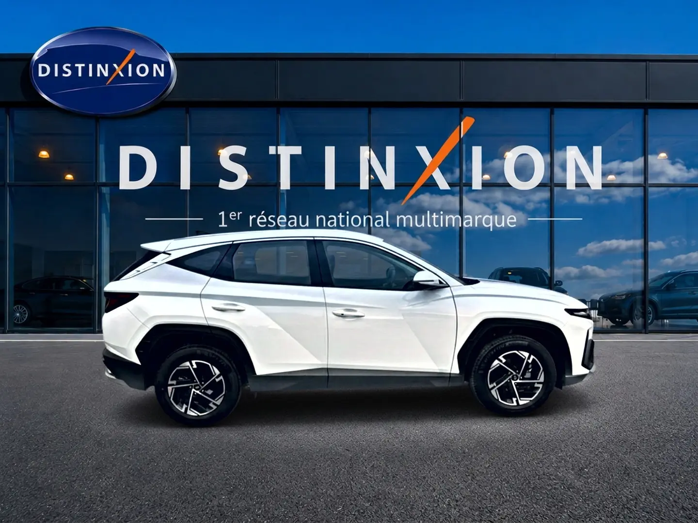Profil latéral gauche d'un Hyundai Tucson blanc 2026 avec jantes alliage et lignes anguleuses modernes.