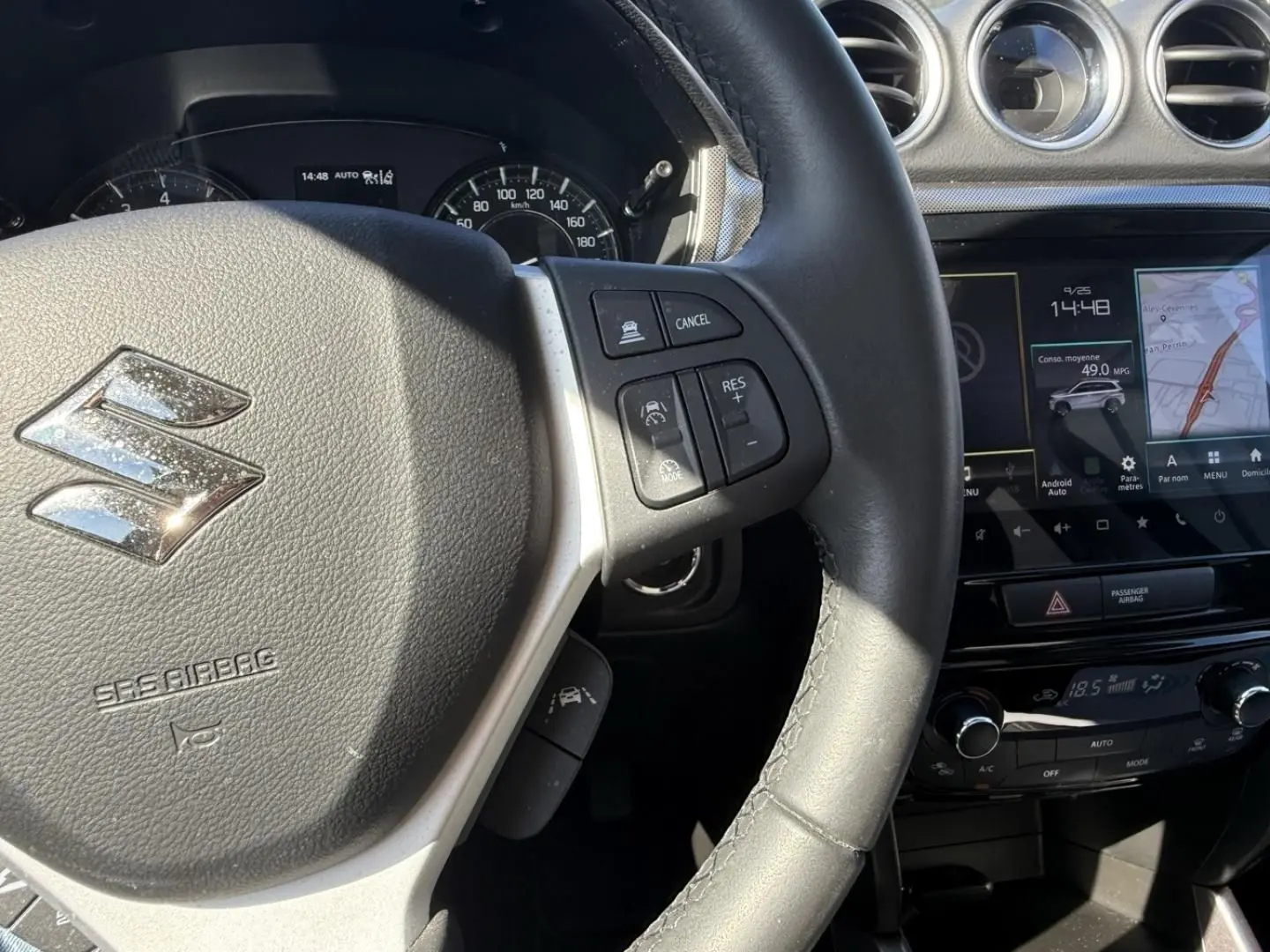 Vue rapprochée du volant et tableau de bord du Suzuki Vitara 2025, avec commandes au volant et écran tactile visible.