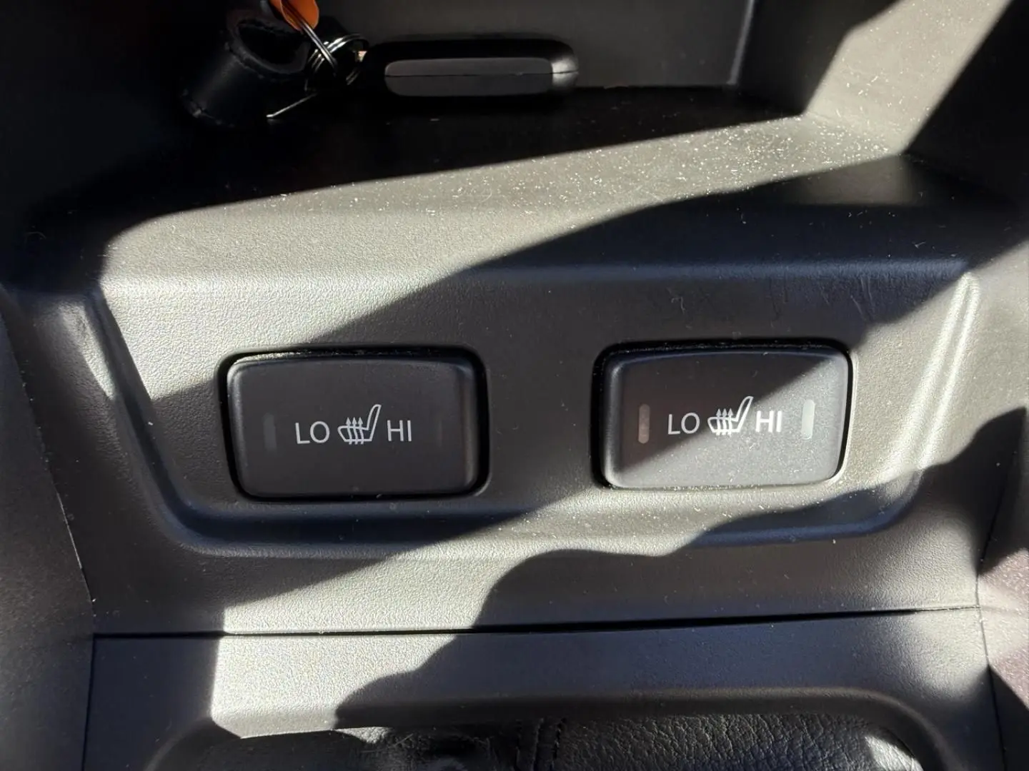 Gros plan sur les commandes des sièges chauffants avec réglages LO et HI dans un Suzuki Vitara bleu foncé 2025.