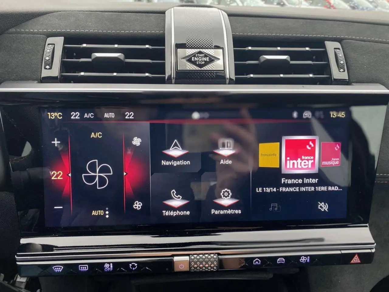 Vue rapprochée de l’écran tactile central du DS7 Crossback gris foncé, affichant la climatisation et les options multimédias.