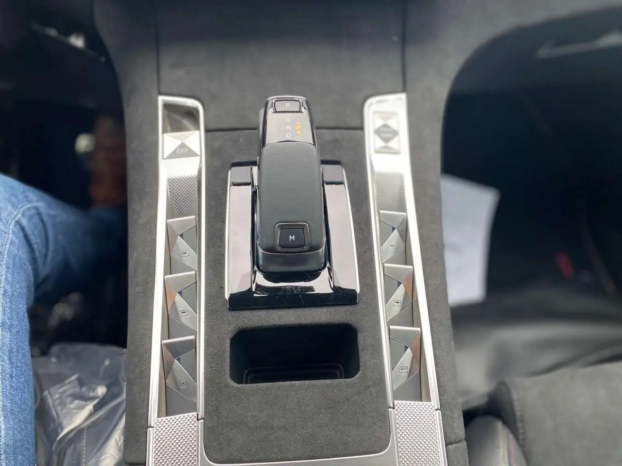 Gros plan sur la console centrale du DS7 Crossback 2024 gris foncé, mettant en valeur le levier de vitesse automatique et les boutons argentés.