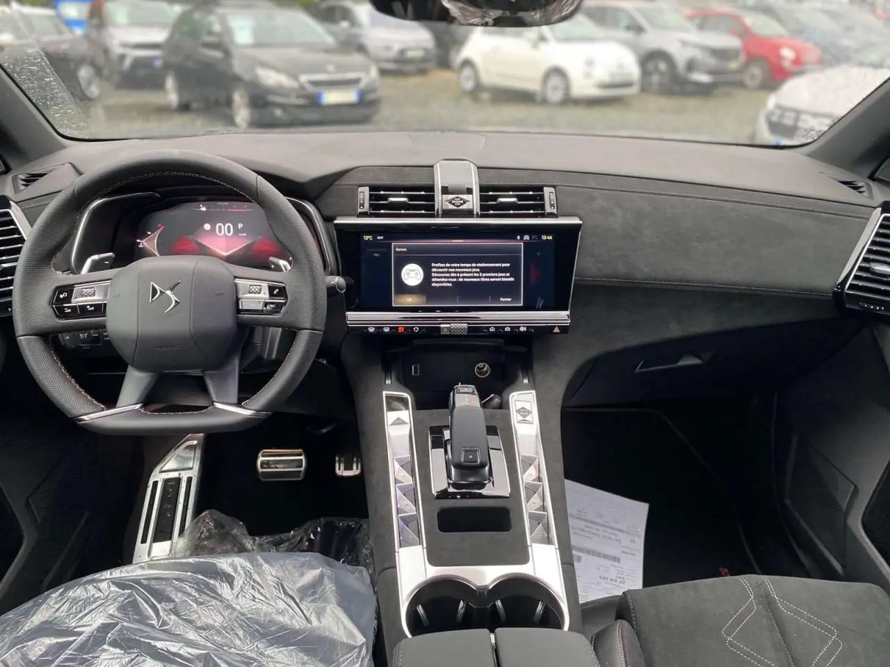 Vue intérieure avant du DS7 Crossback 2024 gris foncé, mettant en valeur le tableau de bord numérique et la console centrale moderne.