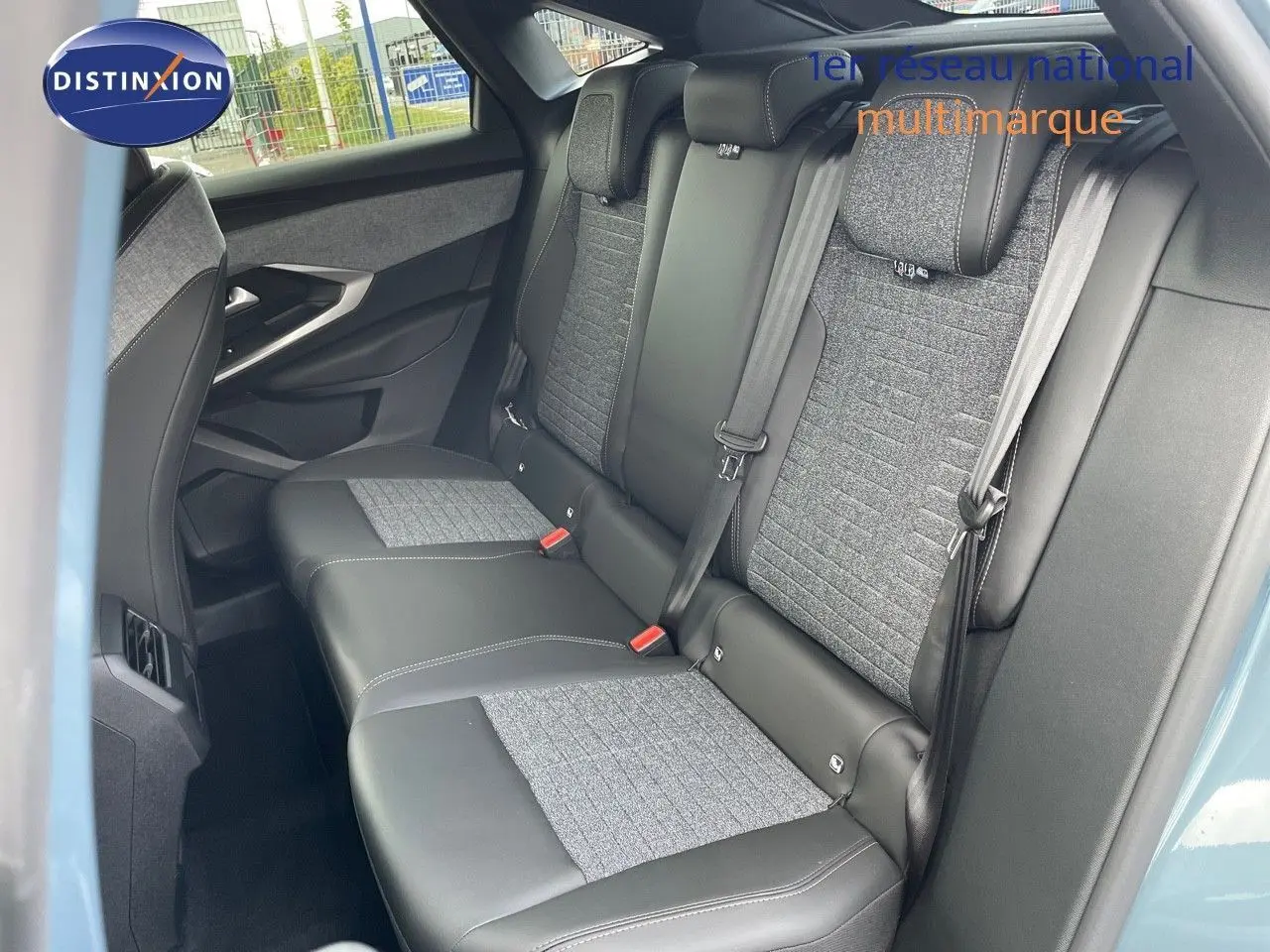 Vue latérale intérieure sur les sièges arrière en cuir noir et tissu gris du Peugeot 3008 Hybrid 2025 bleu Ingaro Metal.