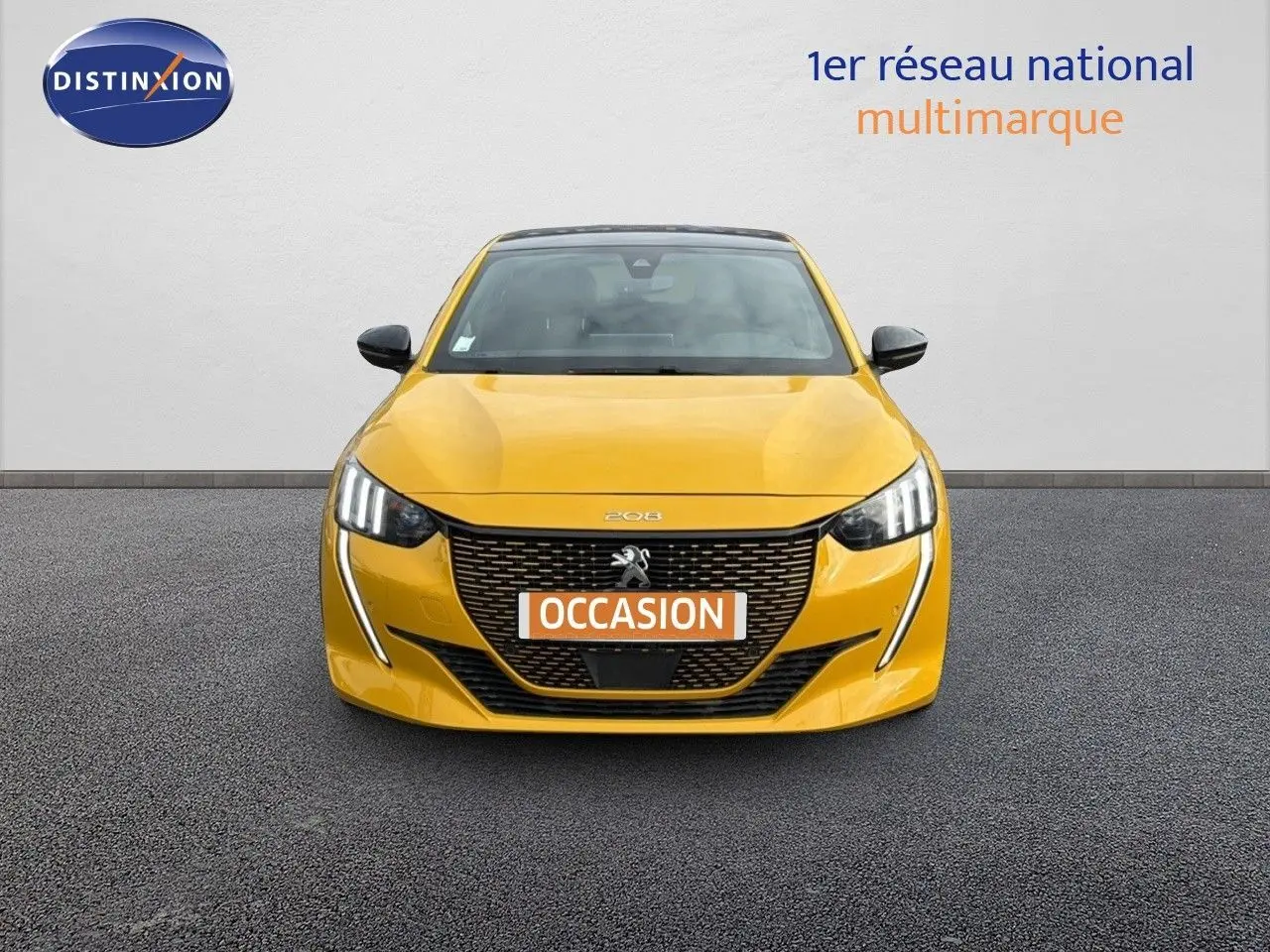 Vue frontale d'une Peugeot 208 électrique jaune Faro métal avec toit noir, mettant en valeur sa calandre distinctive et ses phares LED.