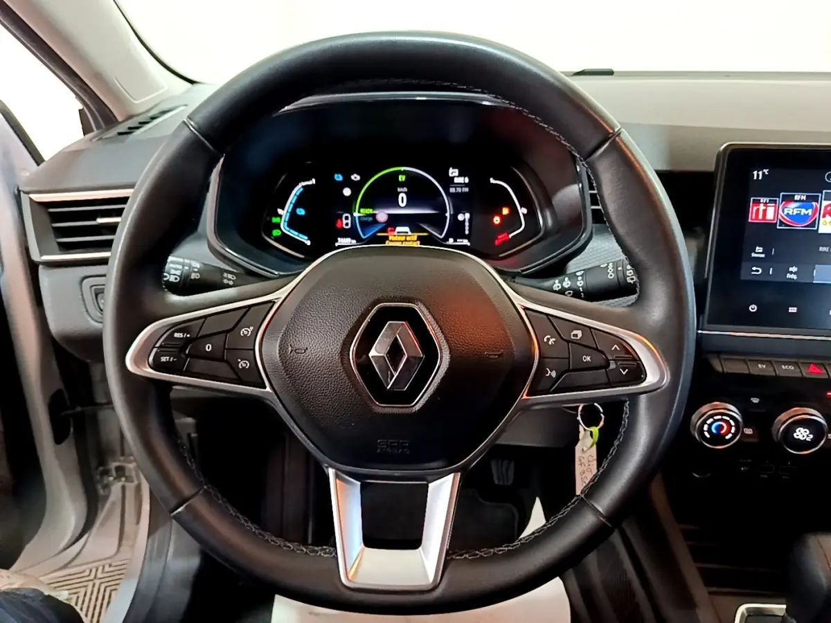 Vue intérieure centrée sur le volant cuir noir et le tableau de bord numérique de la Renault Clio Business E-TECH 140 gris foncé.